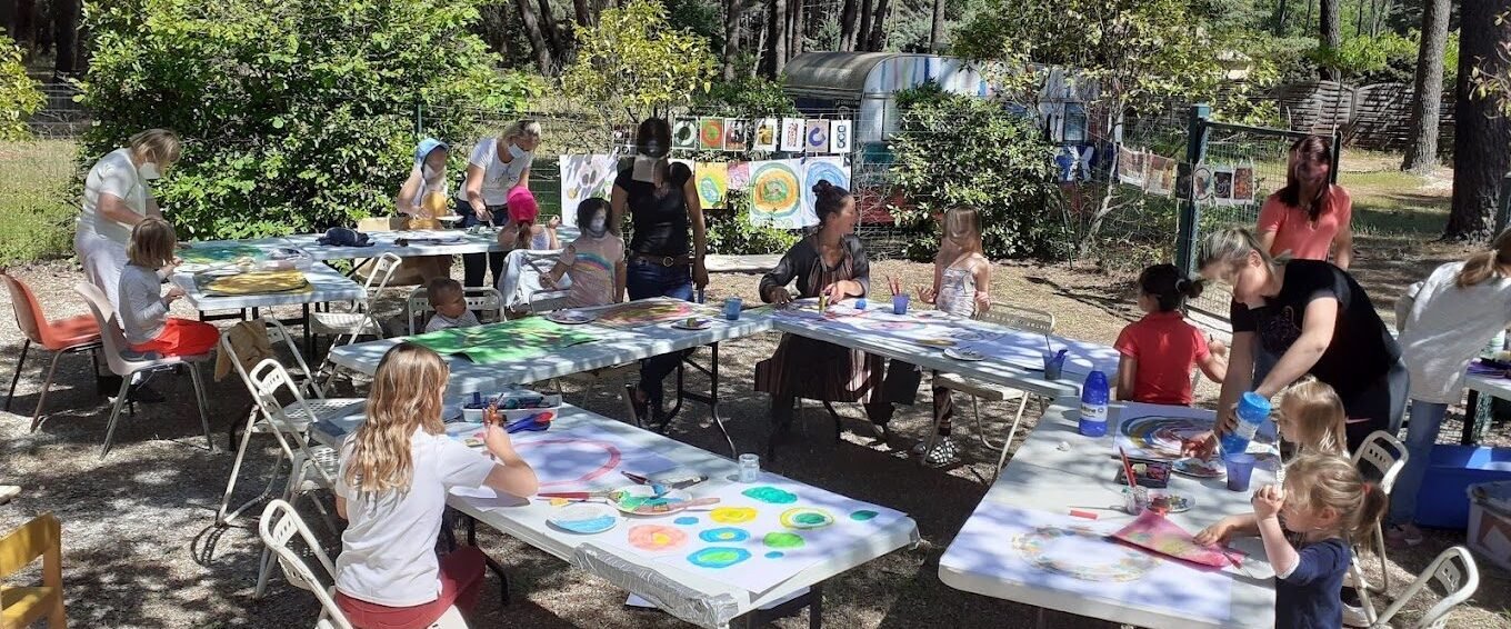 Atelier d'art-thérapie en extérieur, tables sous les arbres